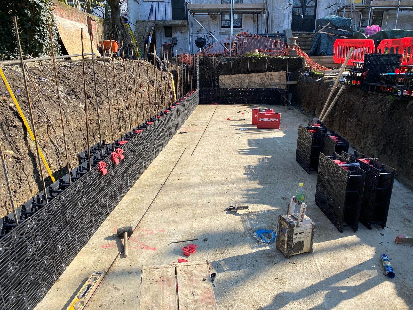 Swimming pool wall system and reinforcement taking shape